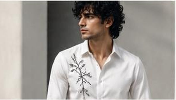 Model wearing embroidered white RENIMS shirt
